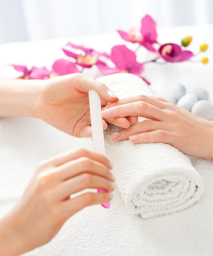 Nude manicure being shaped with a glass file